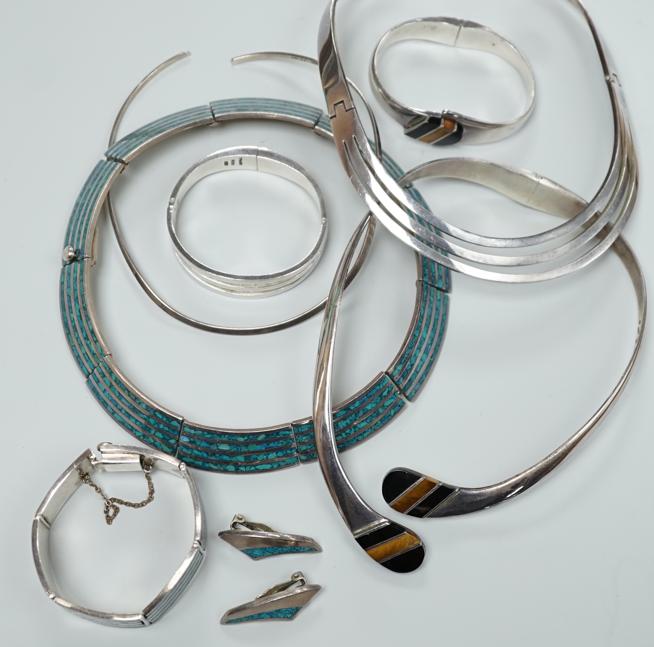 A Mexican 925 hinged necklet, 15.8cm (top to bottom) and matching bracelet, a similar suite of 925 and turquoise and enamel? jewellery, comprising a necklet, bracelet and pair of ear clips, a similar 925, black onyx and